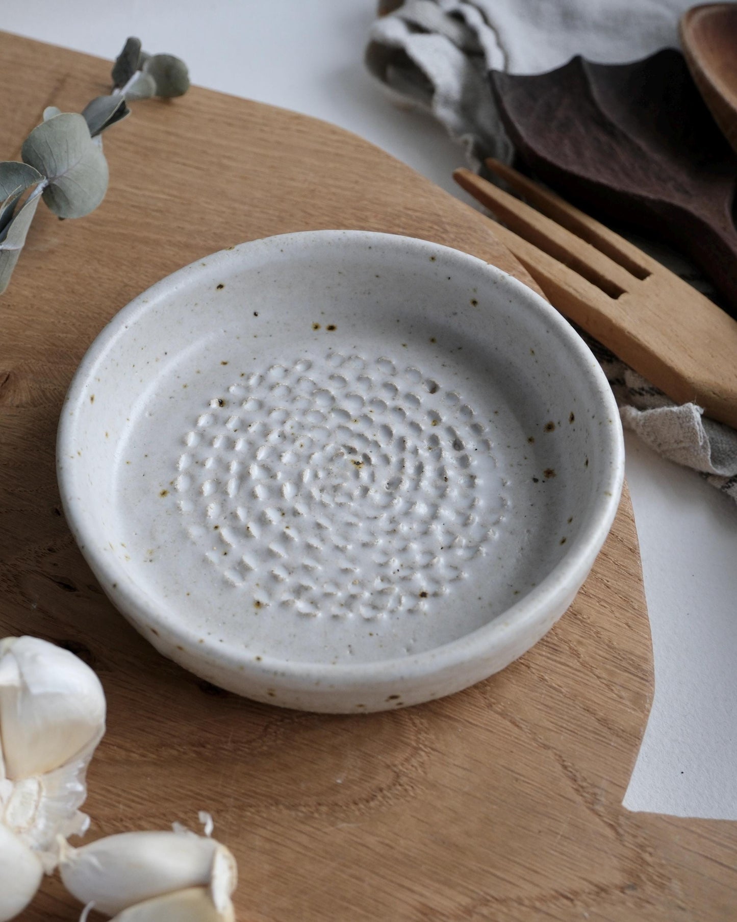 White ceramic grater dish with textured surface on a wooden surface