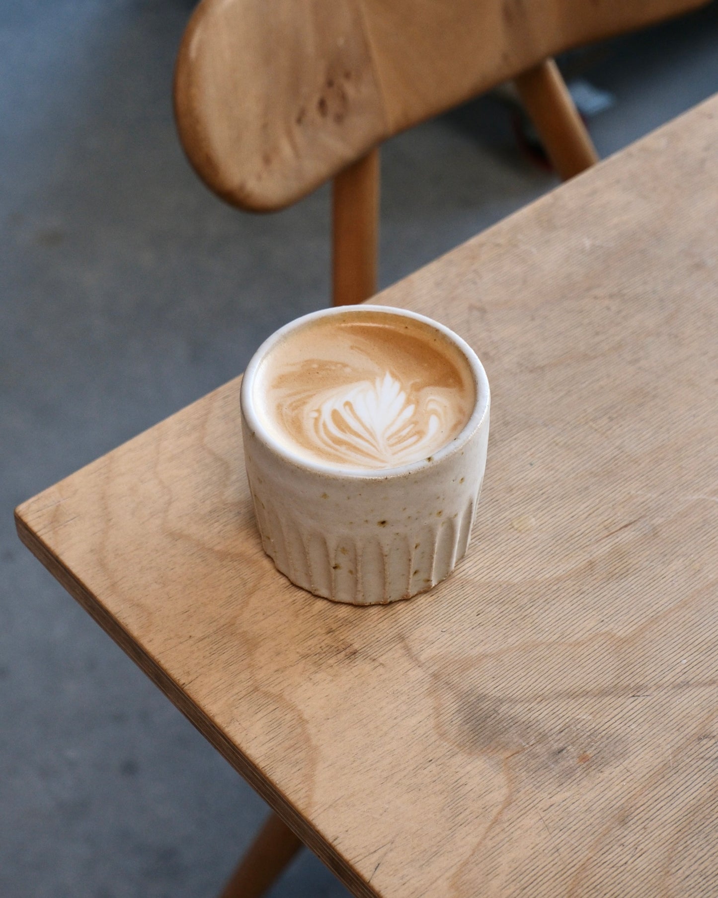 white Ceramic cup with latte art on a wooden table