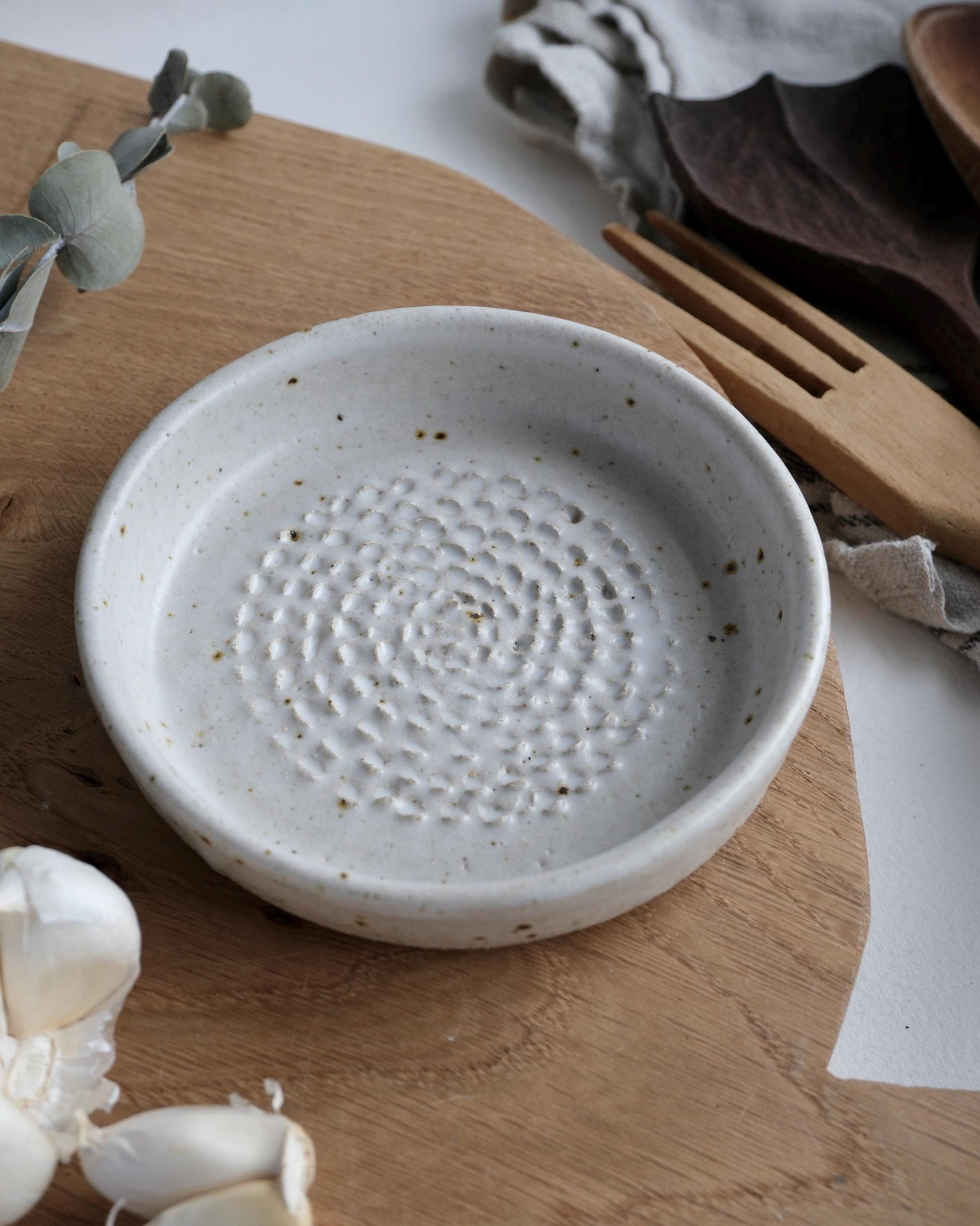 White ceramic grater dish with textured surface on a wooden surface