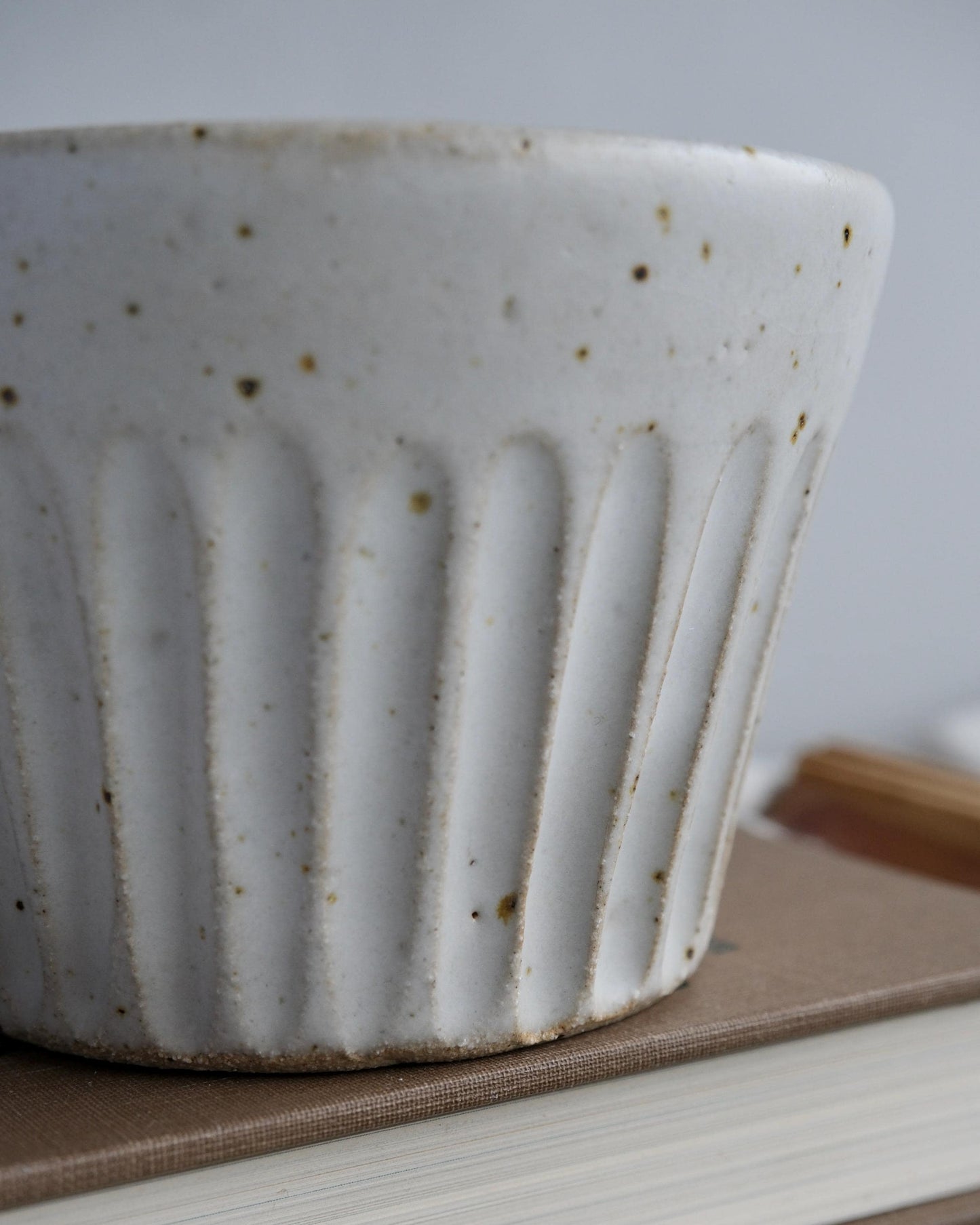 White ceramic mug with textured surface on a wooden surface