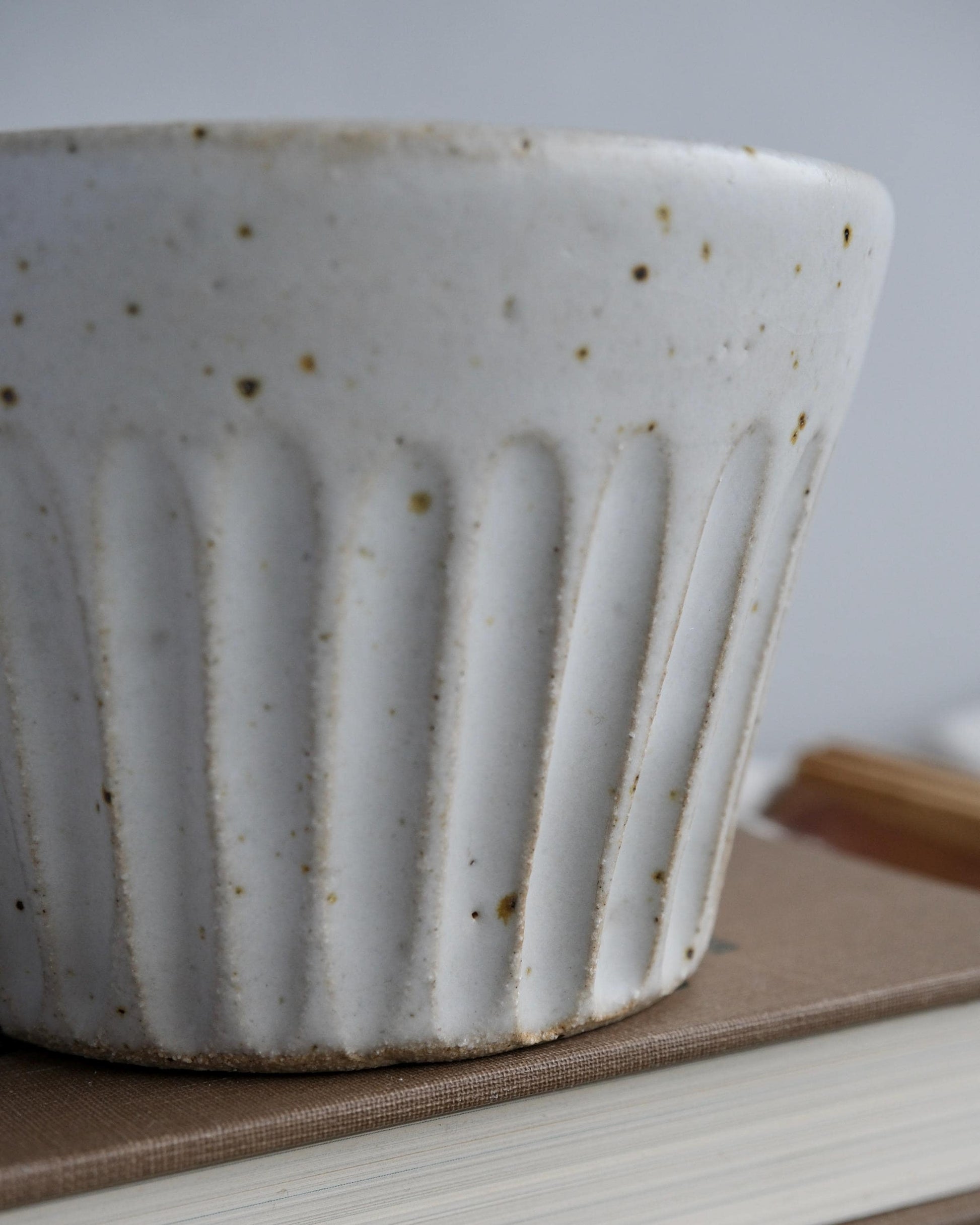 White ceramic mug with textured surface on a wooden surface