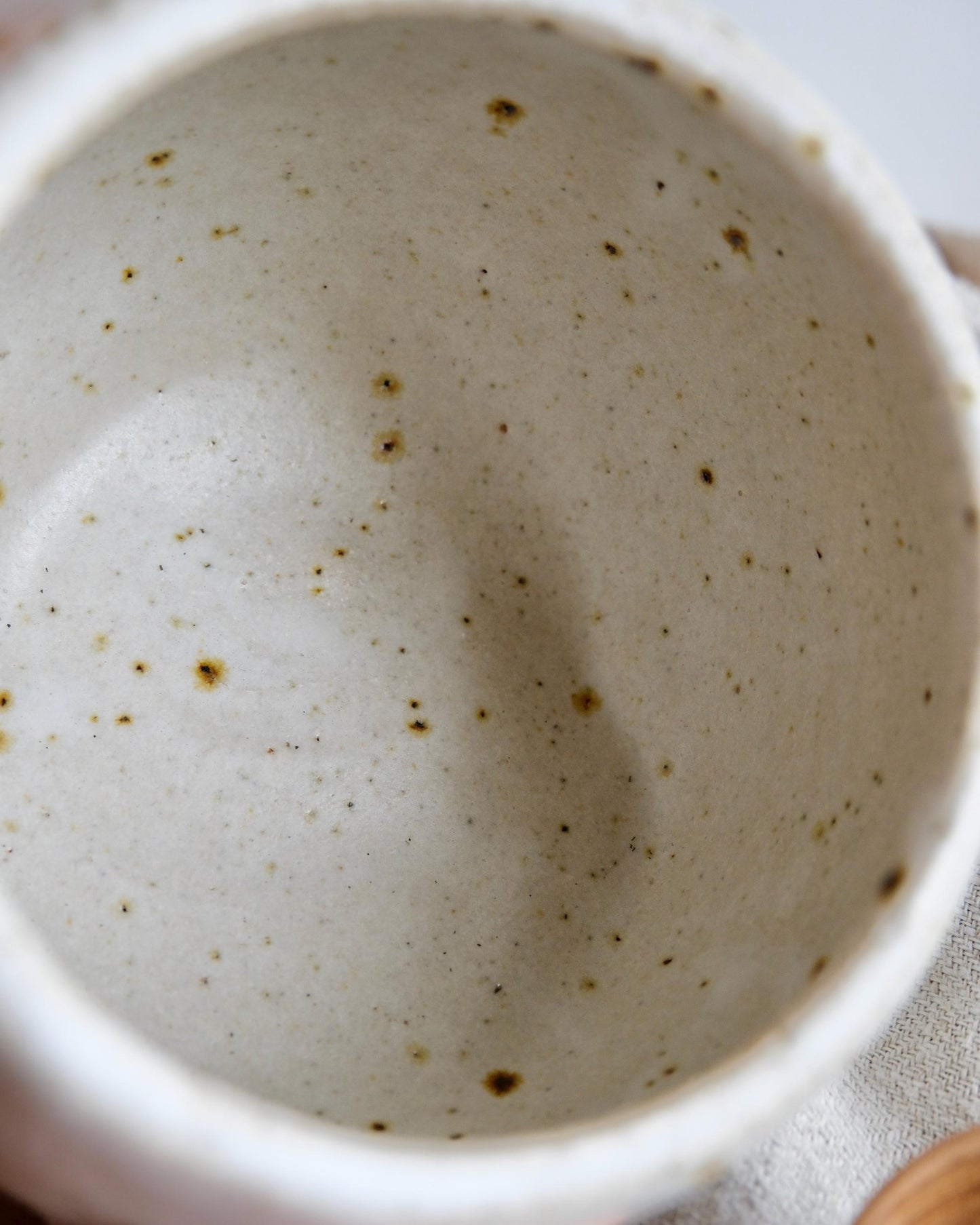 Close-up of a ceramic salt cellar with speckled pattern on a light background