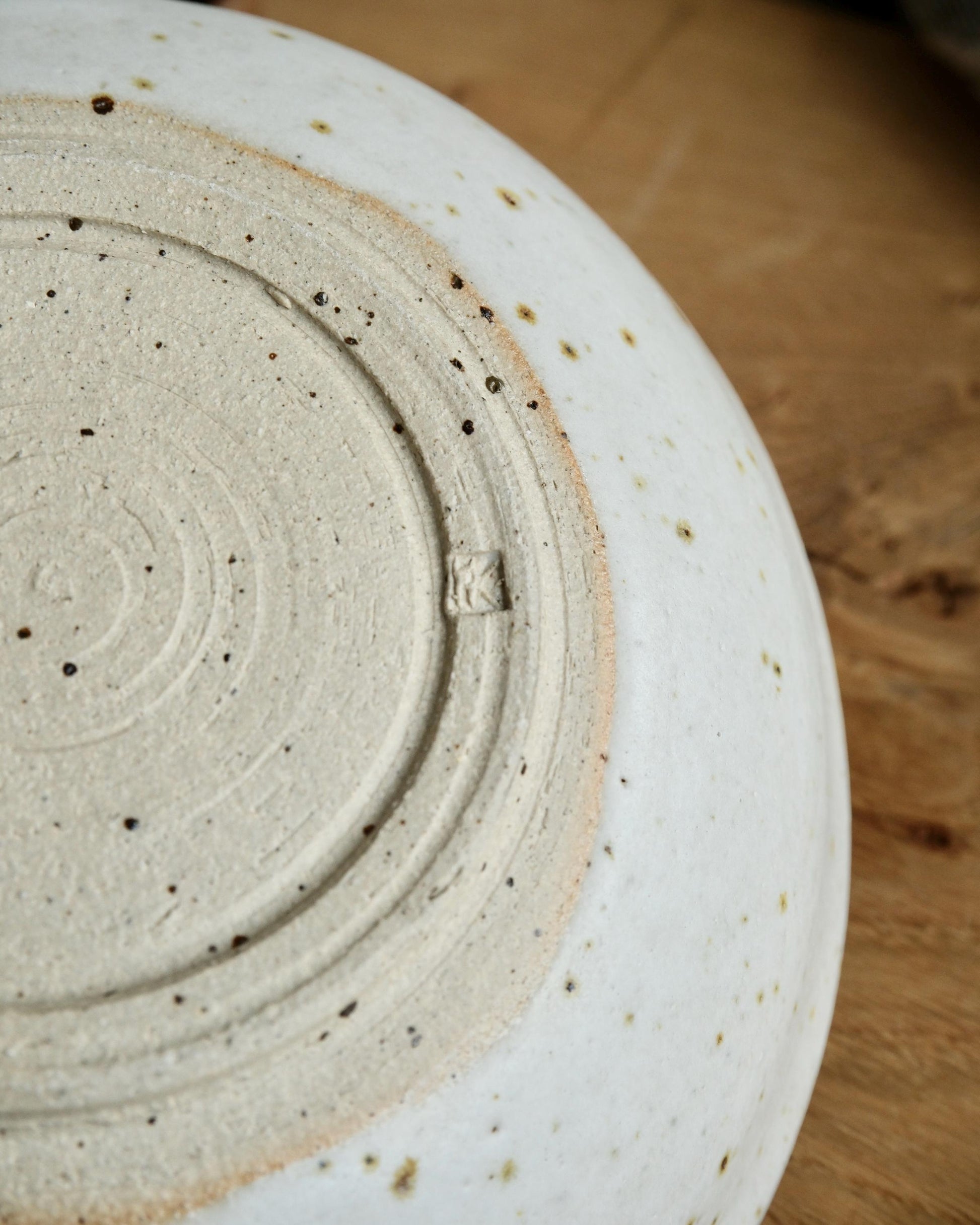 Close-up of a ceramic plate with textured surface on a wooden surface