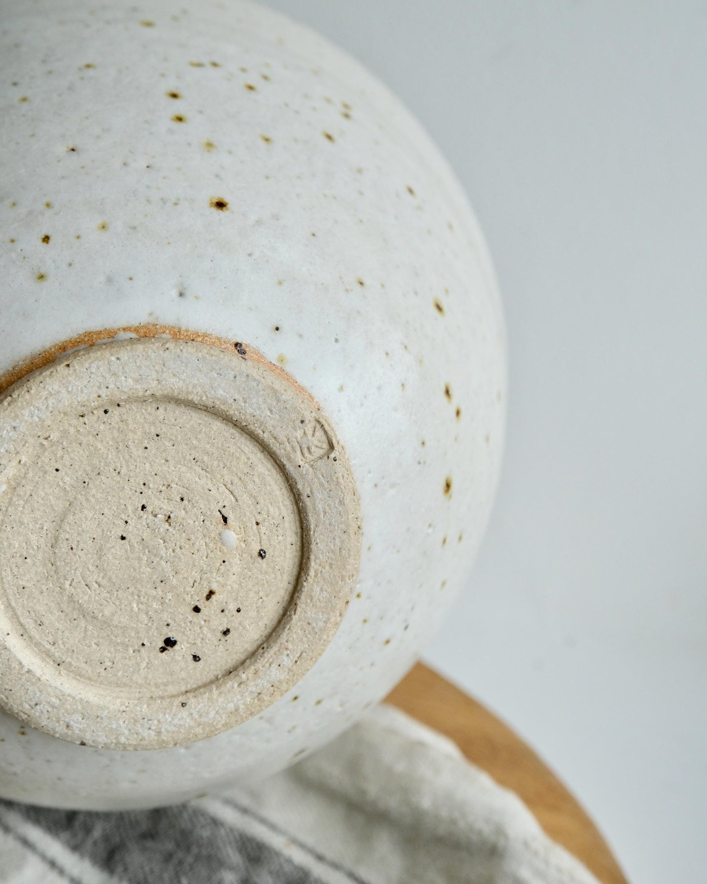 Close-up of a ceramic vase with a textured surface on a light gray background