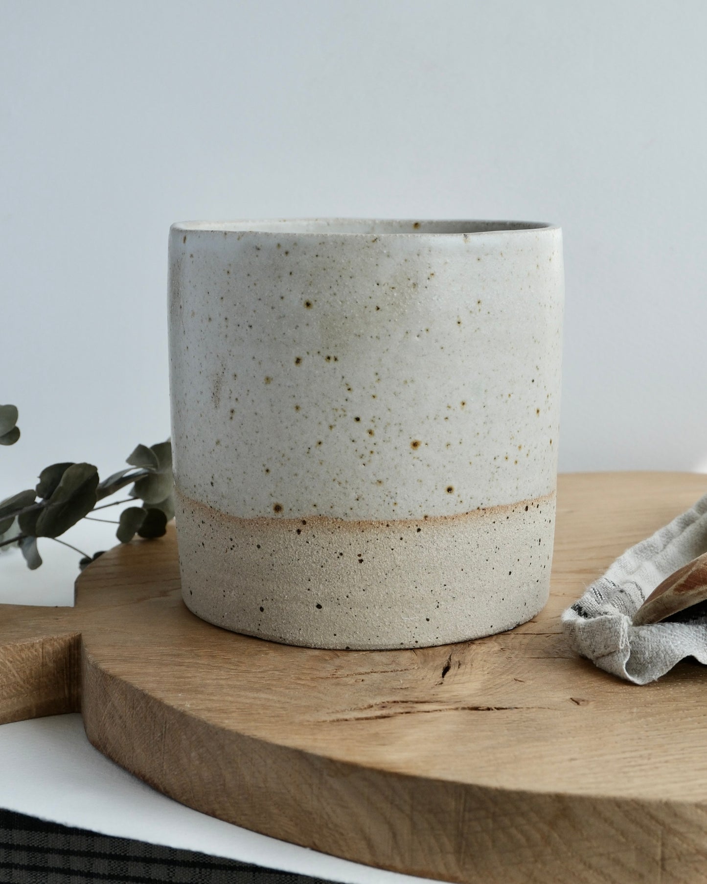 white Ceramic pot on a wooden surface with a light background