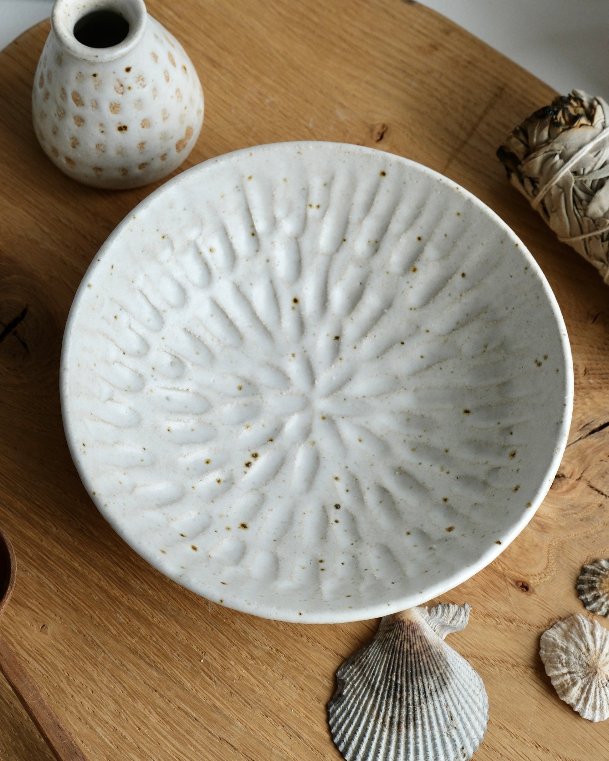 a picture from above of a white ceramic dish with a carved design
