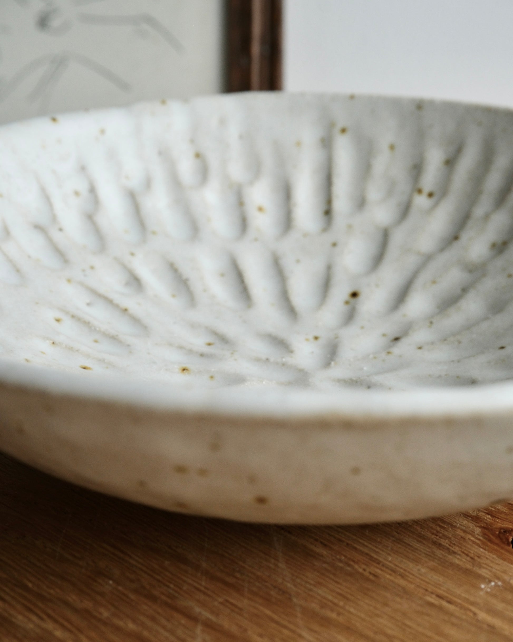 White ceramic bowl with textured surface on a wooden surface