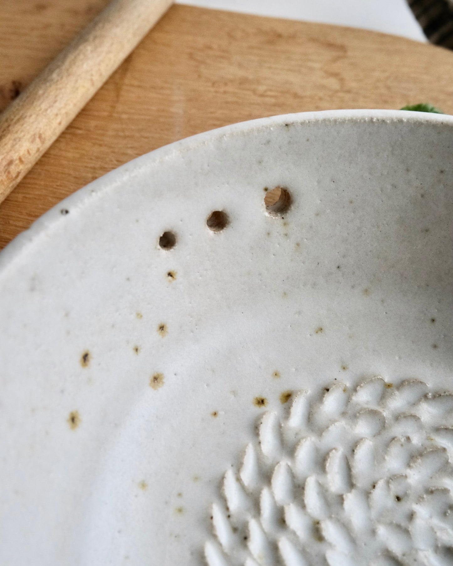 Close-up of a ceramic plate with textured design on a wooden surface