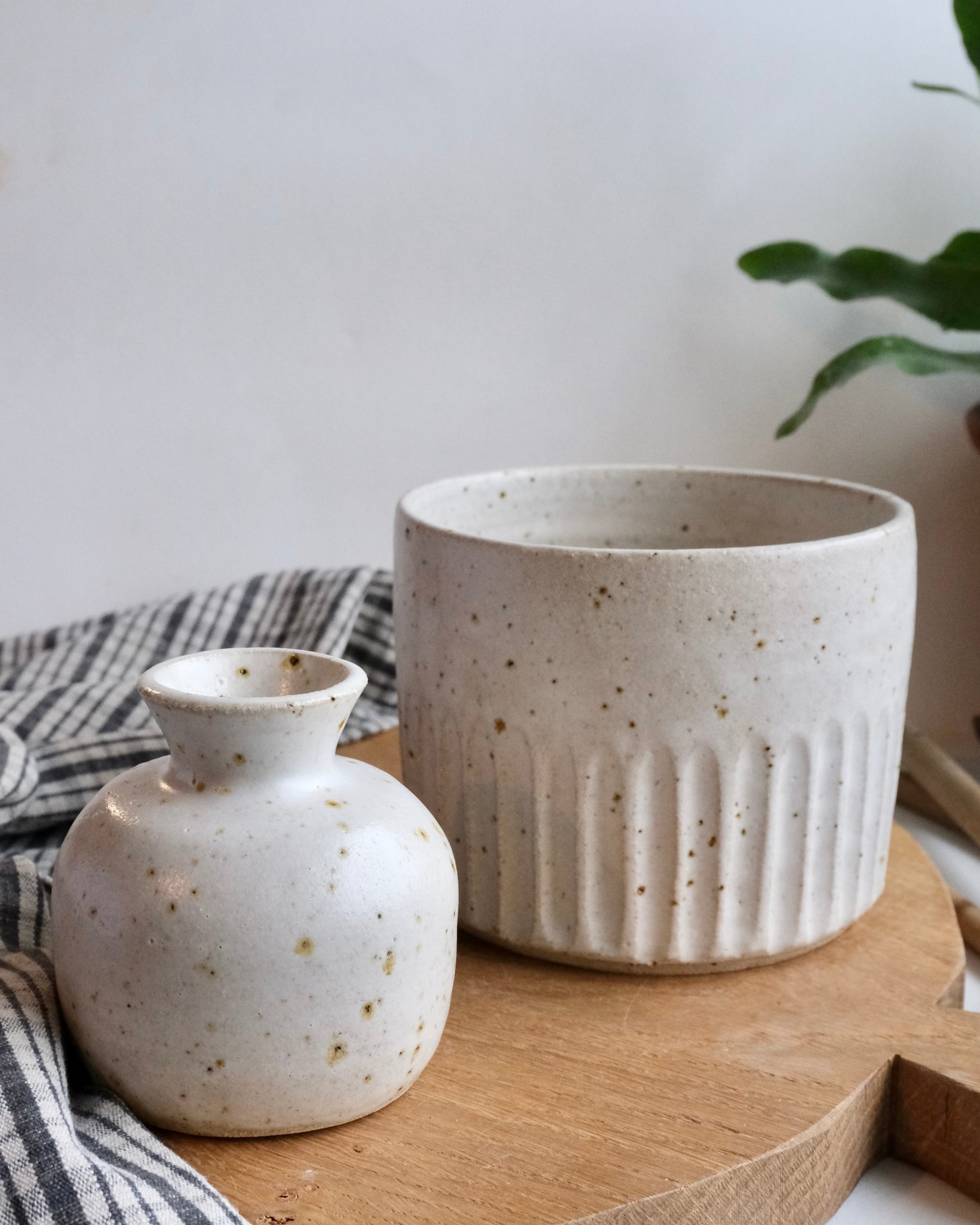 A collection of white ceramic pot and bud vase