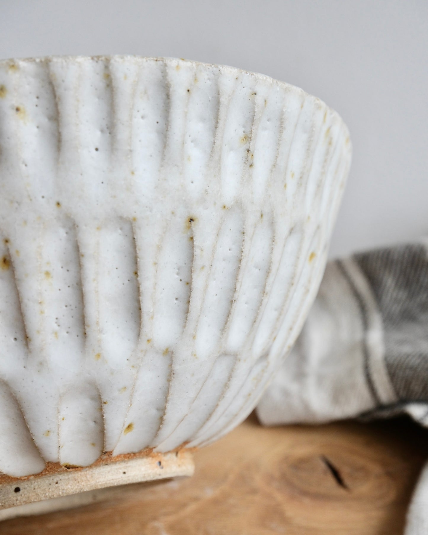 Close up of a textured white bowl with a carved pattern 