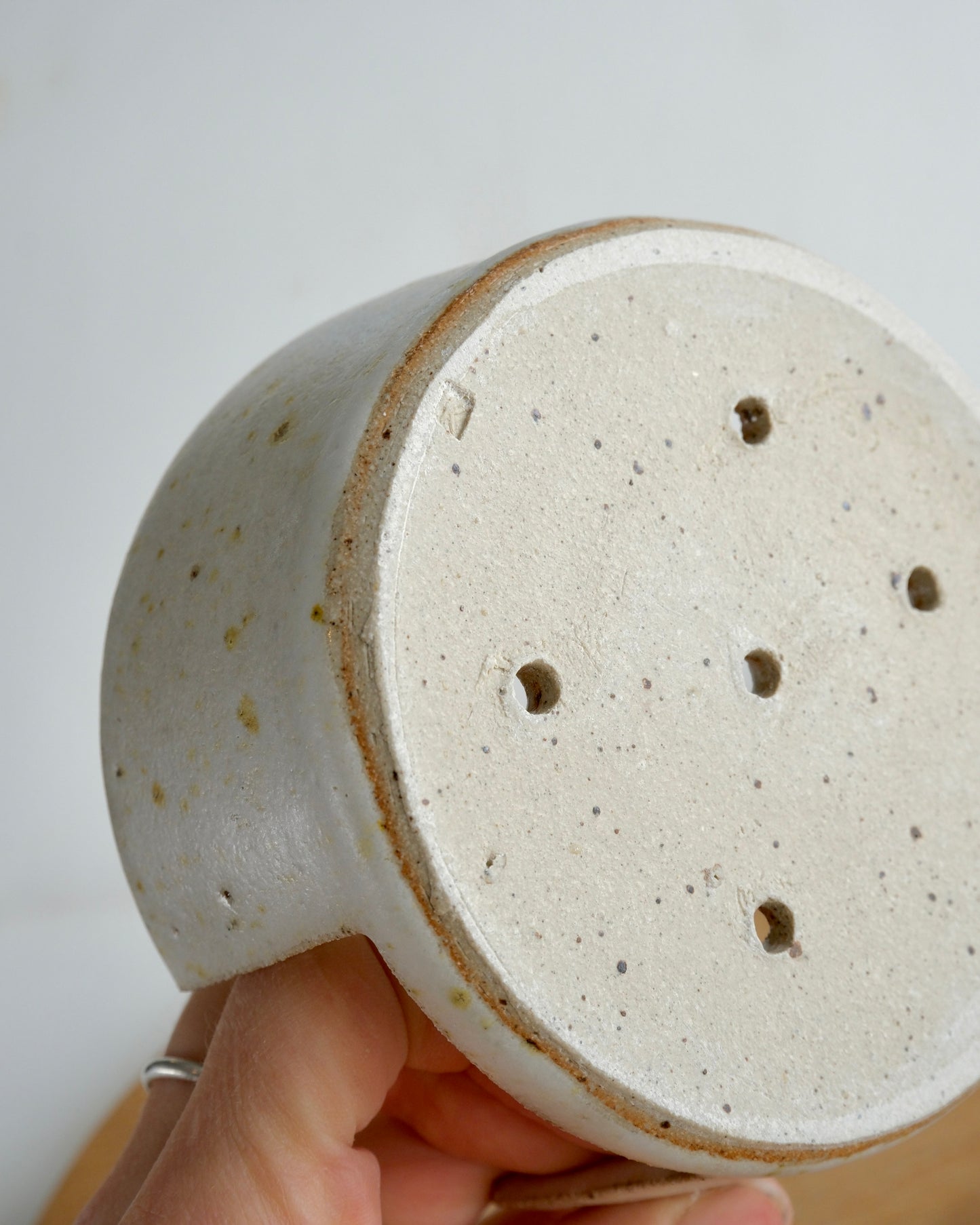 The back of a ceramic sponge holder with drainage holes