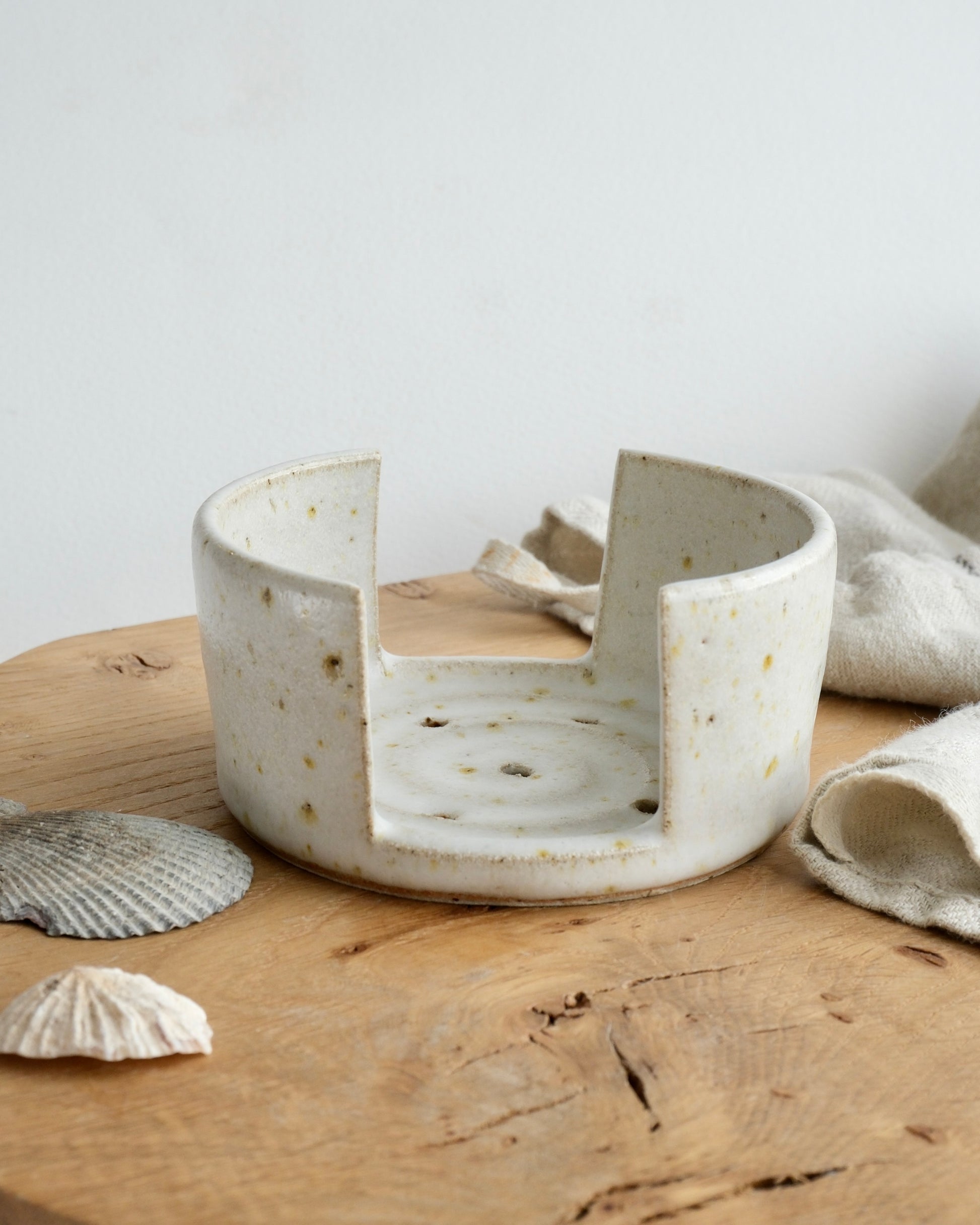 The side view of a white speckled pottery sponge holder 