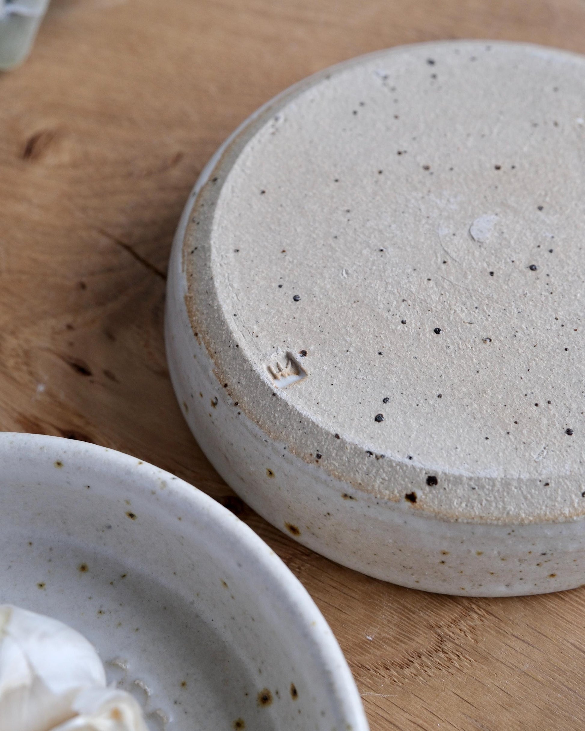 bottom of a Speckled ceramic dish on a wooden surface